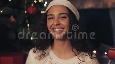 特写<strong>穆拉托</strong>年轻美丽的女孩的肖像，看着快乐，微笑着坐在相机，坐在舒适的圣诞节